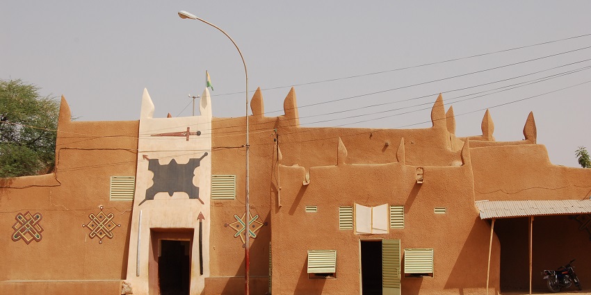 Entrance to the sultan's palace of Zinder with unique architecture and distant motorbikes parked