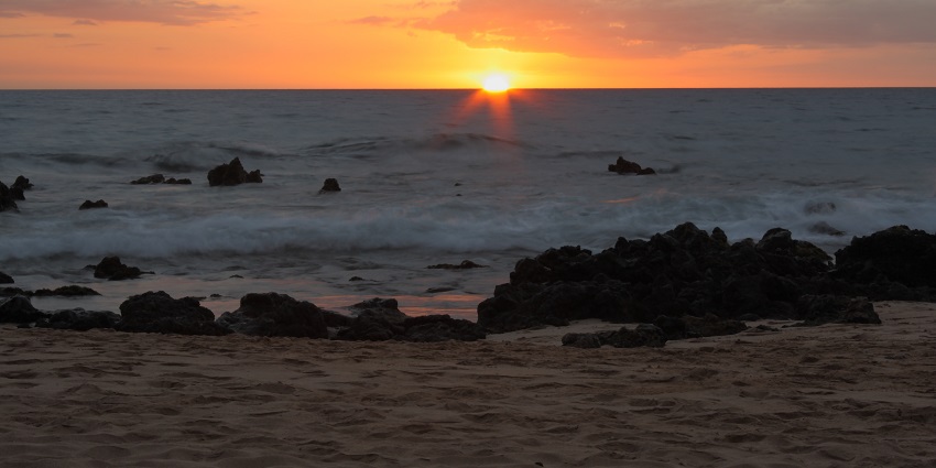 Watch the sky explode in colour as the sun sets over Keawakapu Beach’s tranquil waters.