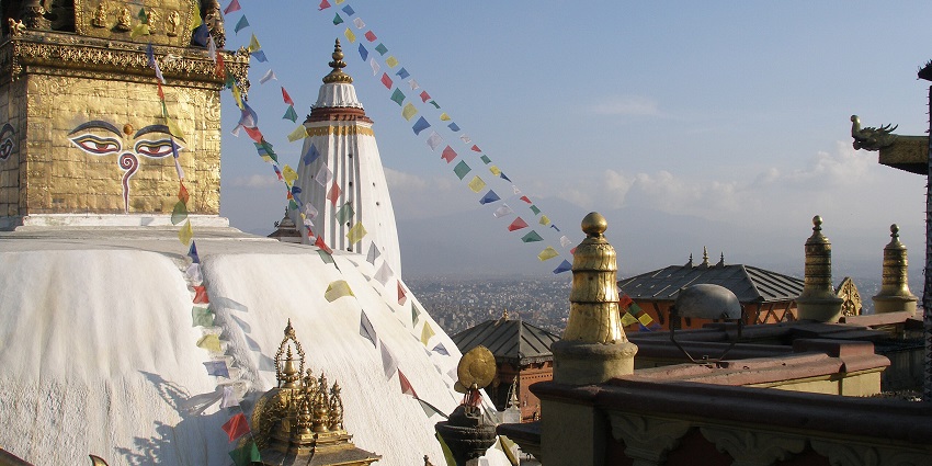 Swayambhunath Stupa with golden spire and colourful prayer flags in Kathmandu, Nepal.