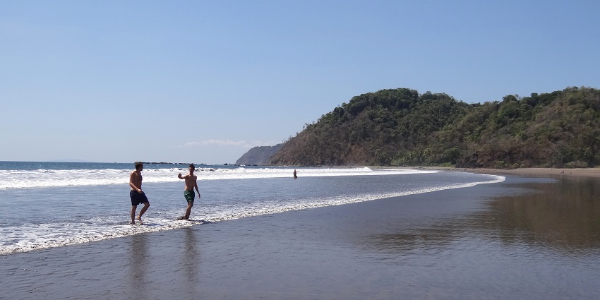 A learner rides soft waves with a surfboard, enjoying one of the most fun things to do in Costa Rica.