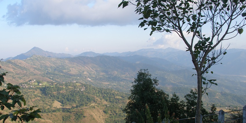 Aerial view of Tansen in Nepal, showing terraced hills, mountain trees, and greenery