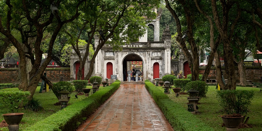 The Temple of Literature's main gate in Hanoi, framed by lush greenery and traditional style.