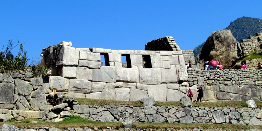Stone walls with large trapezoidal windows, one of the Machu Picchu historical places.