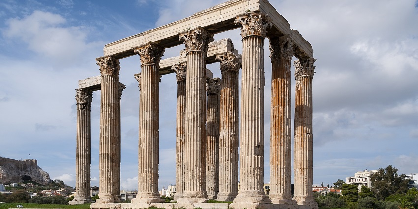 A single towering Corinthian column, one of the grand ancient monuments in Greece.