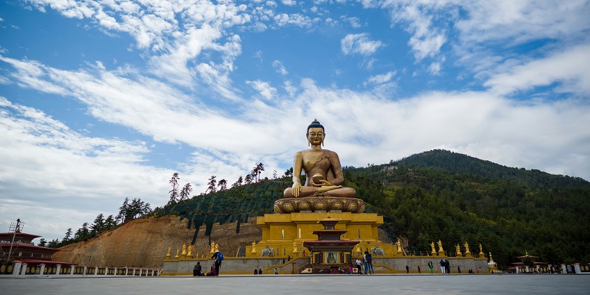 Golden Buddha under sky reflects peace, answering 'Is Bhutan Worth Visiting?'
