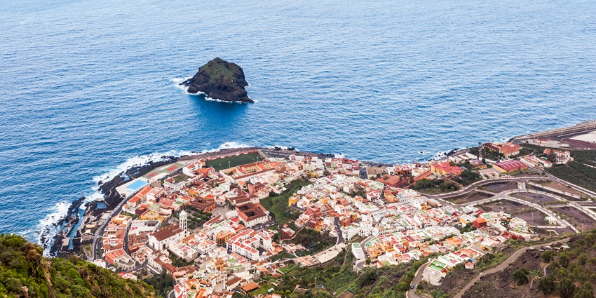 A breathtaking view of lush green Tenerife, volcanic peaks, and one of the Canary Islands.