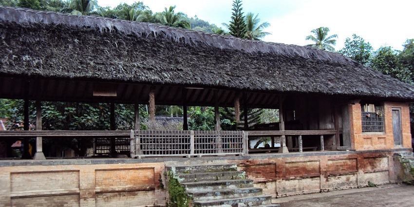 Traditional Bali Aga houses in Tenganan village with stone walls and thatched rooftops.