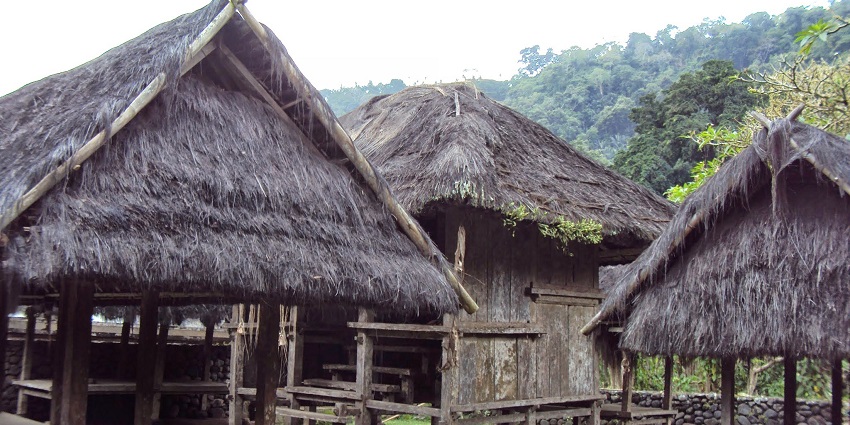 Traditional open-air wooden pavilion with thatched roof in Tenganan Village in Bali.