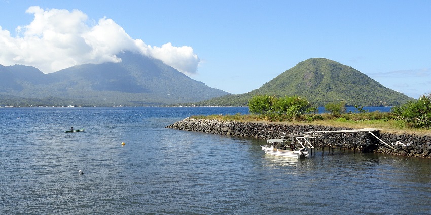 Serene view with calm waters with a lush mountain island, amongst the best places to visit in Indonesia in January.