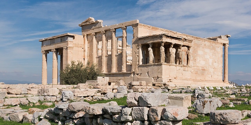 The ancient Erechtheion temple on the Acropolis of Athens with Caryatid columns and ruins, one of the top historical places in Greece.