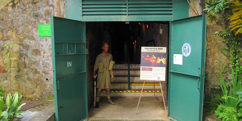 Visitors walking through a dimly lit tunnel inside the Battle Box, one of the famous historical places in Singapore.
