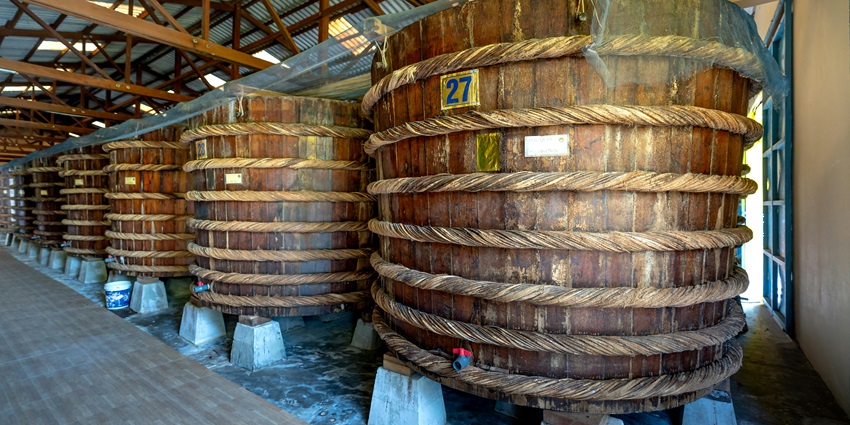 Barrels of beer with metallic build, writings on the barrels and different colour strips.