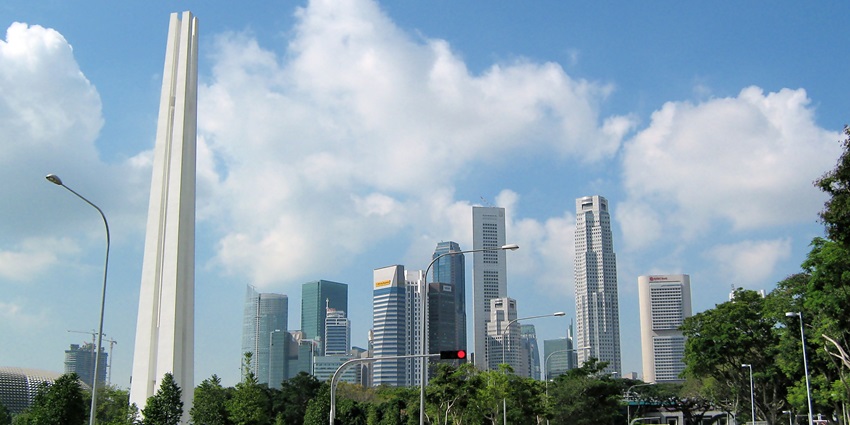 The Civilian War Memorial in Singapore features four tall white pillars, standing in a peaceful park, one of the historical places in Singapore.