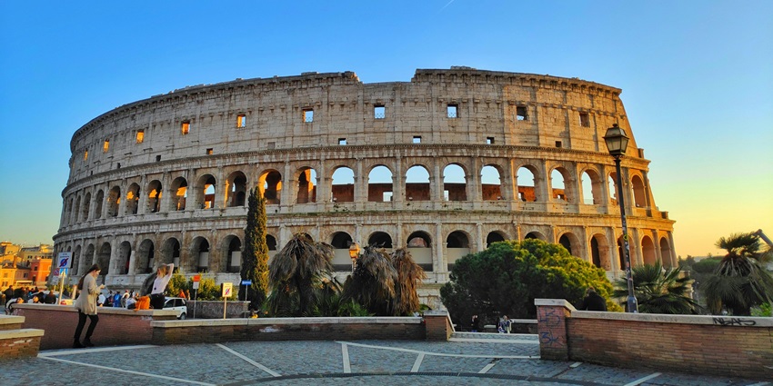 Image of the Roman Colosseum at sunset with a dramatic cloudy sky and ancient architecture, one of the top historical places in Europe