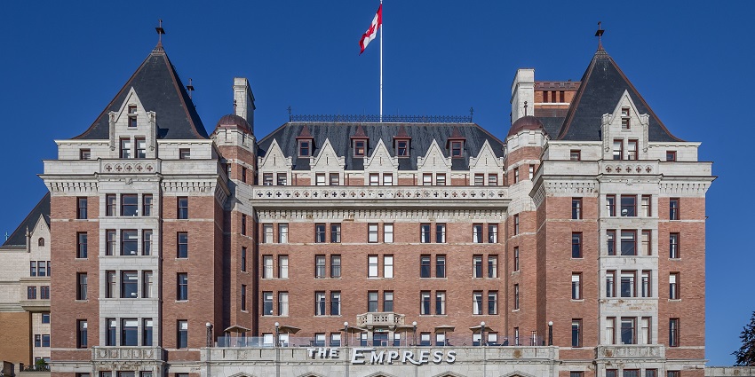 Historic brick hotel with tall towers, arched windows, and one of the top historical places in Victoria.