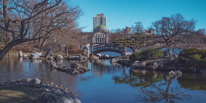 The garden of the phoenix with water of the lake surrounded by rocks and a bridge.