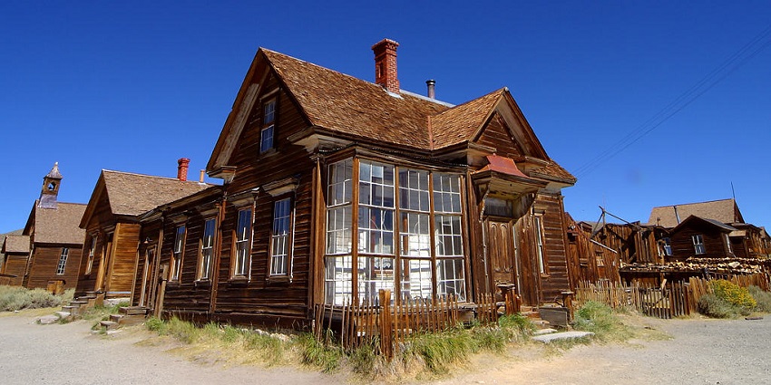 An eerie ghost village with a series of abandoned yet beautiful houses on a bright morning.