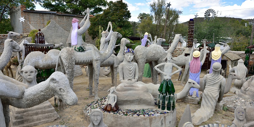 The Owl House Museum in Nieu-Bethesda with multiple different statues and hanging bottles