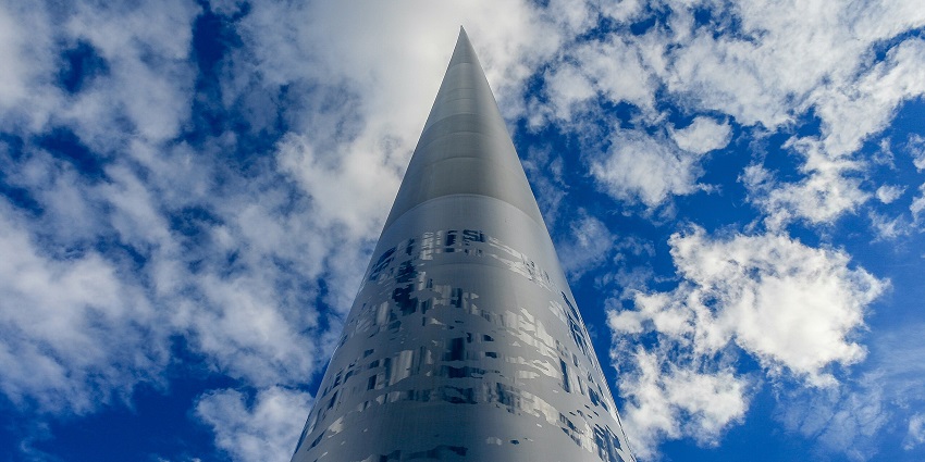 The Spire of Dublin rising high on O’Connell Street against a clear blue sky with clouds