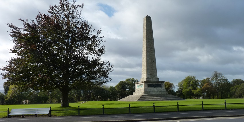 The Wellington Monument in Phoenix Park, Dublin, with a tall tree on the left side