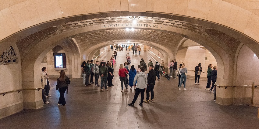The whispering gallery at Grand Central Terminal with multiple people walking and standing