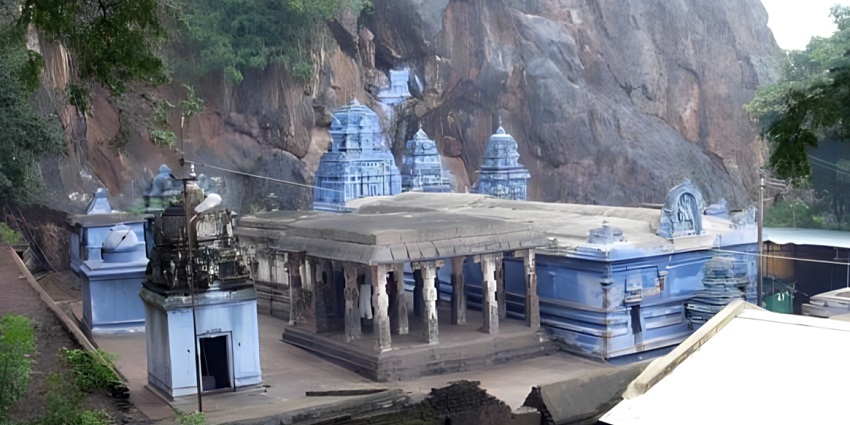 Hilltop temple with ancient stone architecture surrounded by forest and sacred water
