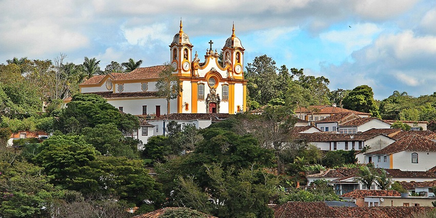 Tiradentes's detailed architectural church with a cross on top and surrounded by buildings