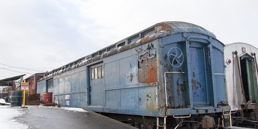 Track 61 in New York with an old abandoned blue train parked and signage at a distance