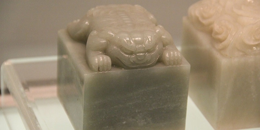 Traditional jade scholar’s seal with intricate carvings and a polished green surface.