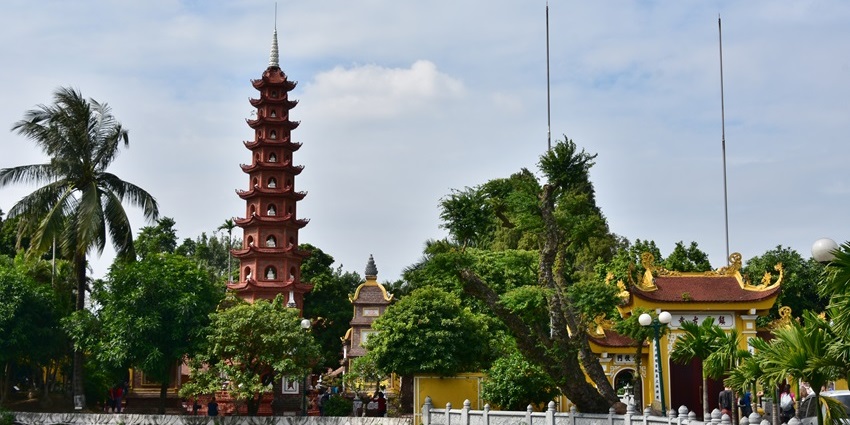 Tran Quoc Pagoda and stupa reflected in West Lake at sunset.