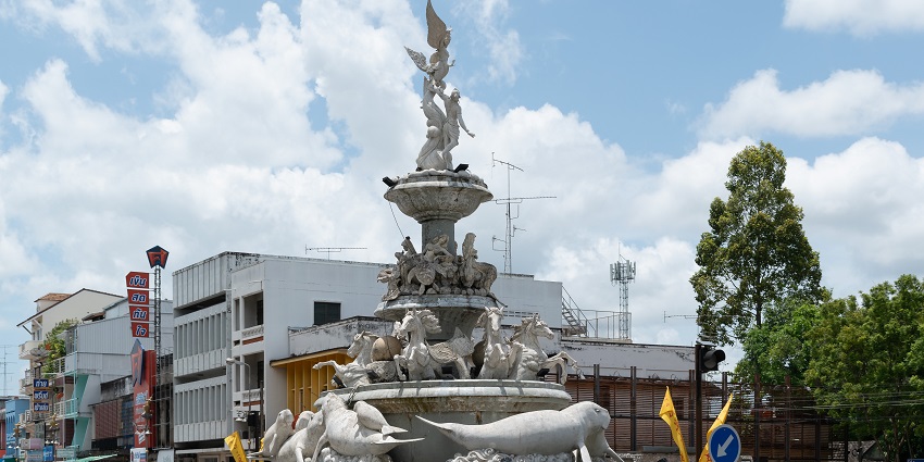 Trang roads with white detailed statues in the middle, is one of the places to visit in Thailand in July.