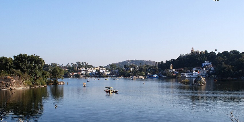 Nakki Lake at Mount Abu with a large water body, boats on the lake and distant buildings.