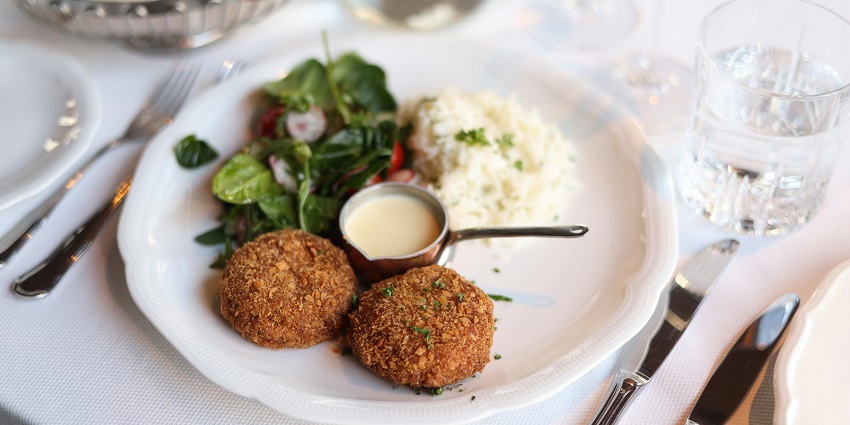 Indulge in Maryland's famous crab cakes, a culinary staple renowned for their rich flavour and tradition.