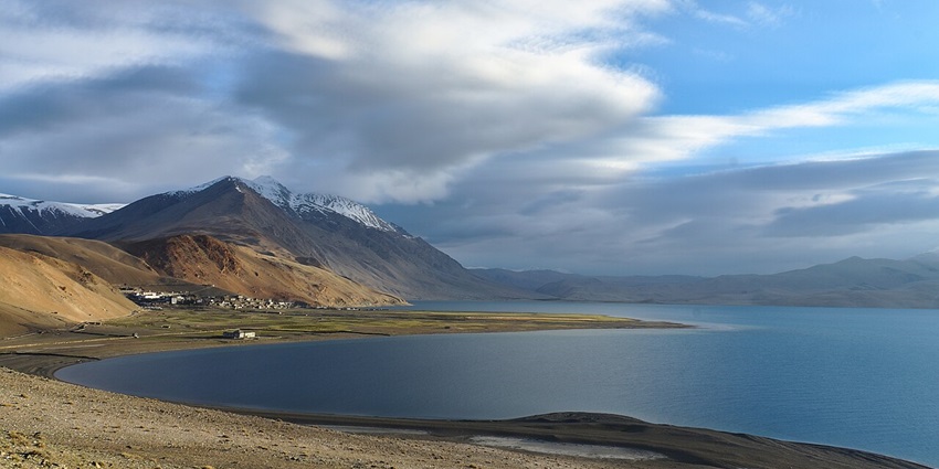 The Pristine Tso Morriri lake with mirrored reflections and barren mountain surroundings.