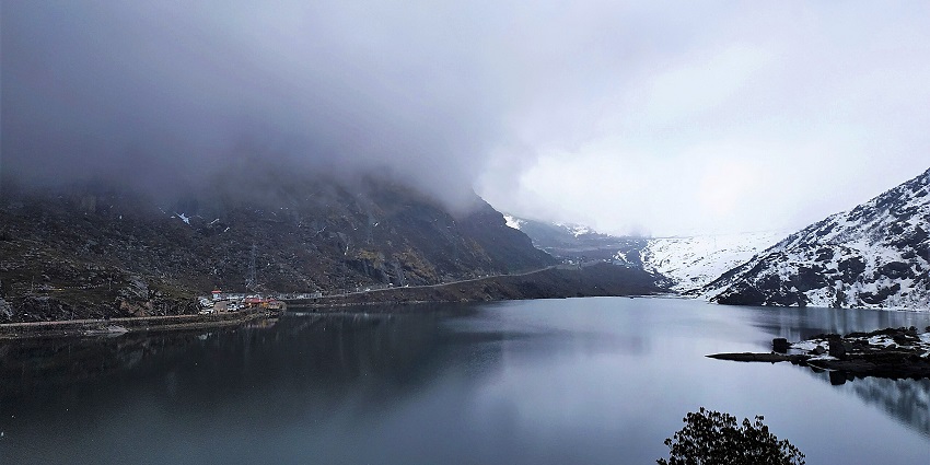 Misty view of Tsomgo Lake in East Sikkim with serene waters and surrounding hills, one of the top places to visit in Gangtok in March.