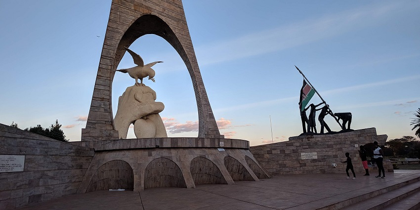 Uhuru Gardens Monument in Nairobi, Kenya, with a few visitors gathered on the right side.