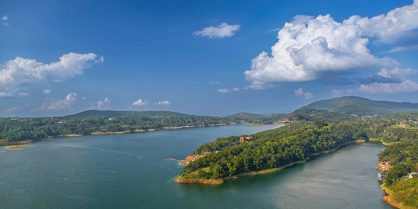 Umiam Lake in the evening with large waterbody, sandy shorelines and people, one of the best places to visit in Shillong in January.