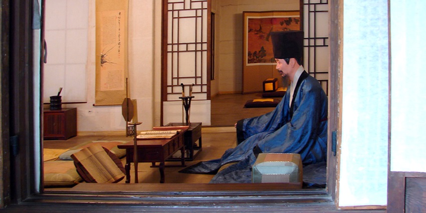 Interior of Unhyeongung Royal Residence with a man sitting in traditional dress