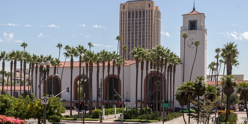 Union Station in Los Angeles, with a tall clock tower, palm trees, is one of the top historical places in Los Angeles.
