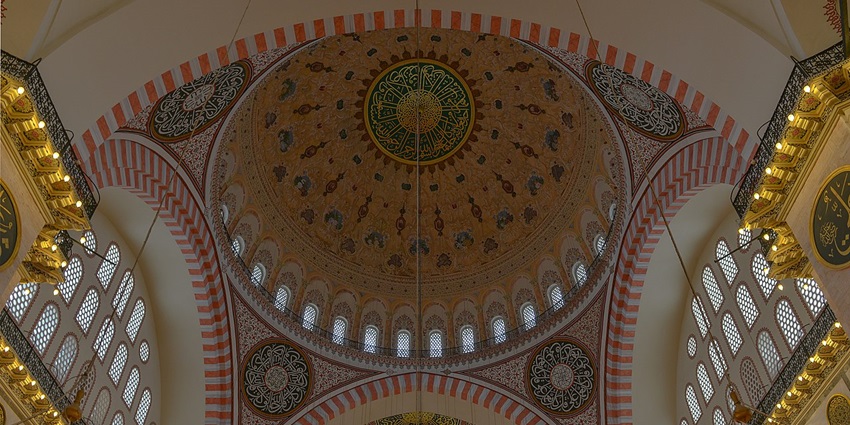 Detailed and colourful ceiling of a mosque with small windows and unique patterns