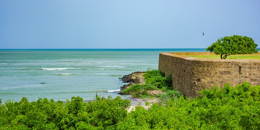 View of the dry stepped tank surrounded by lawns and trees inside the Palace complex.
