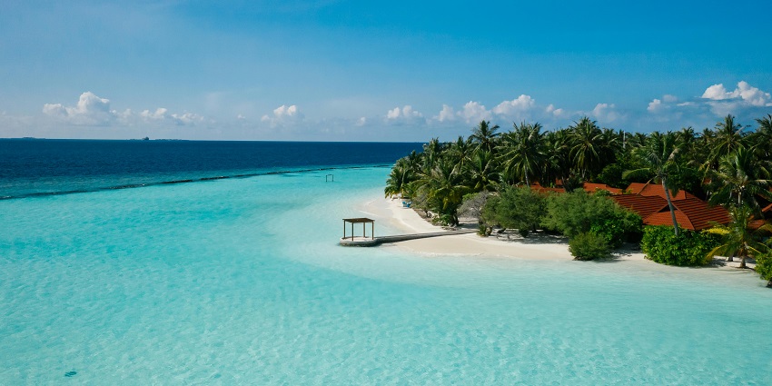Tropical beach with crystal-clear turquoise water, lush palm trees, one of the top islands in Maldives.
