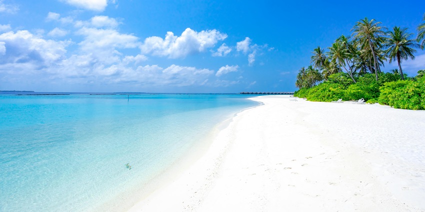 Beach at Villingili Island with sandy shoreline of the beach and bright blue water, one of the places to visit in Maldives in January.