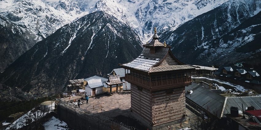 Kunzum Mata Temple set against rugged Himalayan mountains with a clear sky backdrop