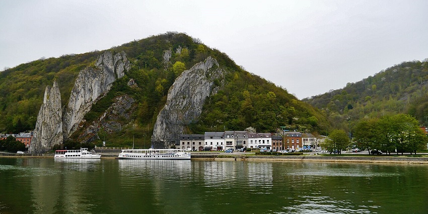 Dramatic vertical rock formation rising beside the Meuse River near Dinant.