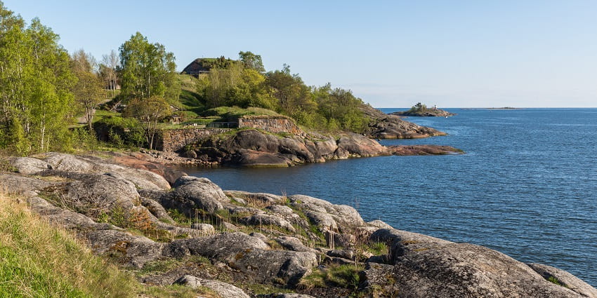 Explore military ruins surrounded by vibrant flora and sea breezes.