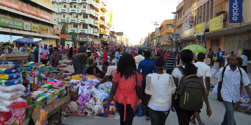 Crowded stalls with colourful umbrellas and busy shoppers at Kariakoo Market show lively things to do in Dar es Salaam.