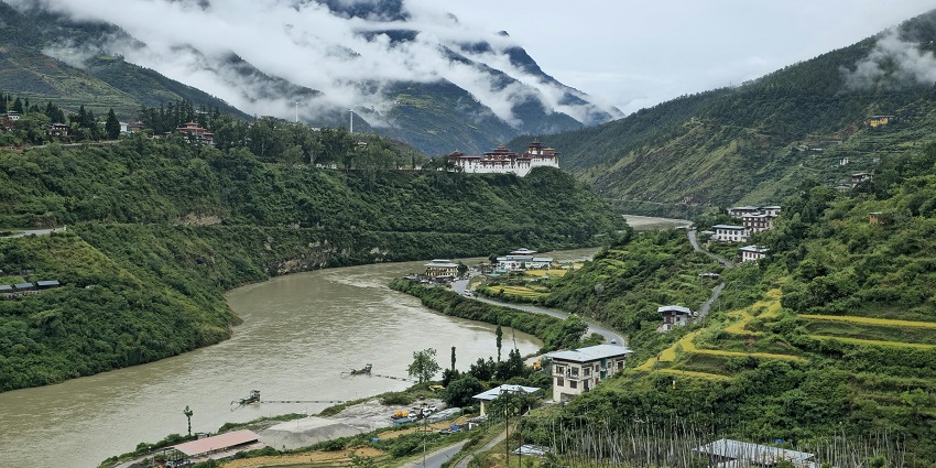 Wangdue Phodrang region, with a river flowing through the valley and distant buildings.
