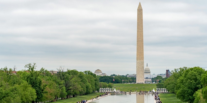 A Towering white obelisk set against a blue sky, on the National Mall, monument in the USA.