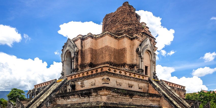Wat Chedi Luang stupa in Chiang Mai, Thailand, showing ancient brick architecture and a clear blue sky background.